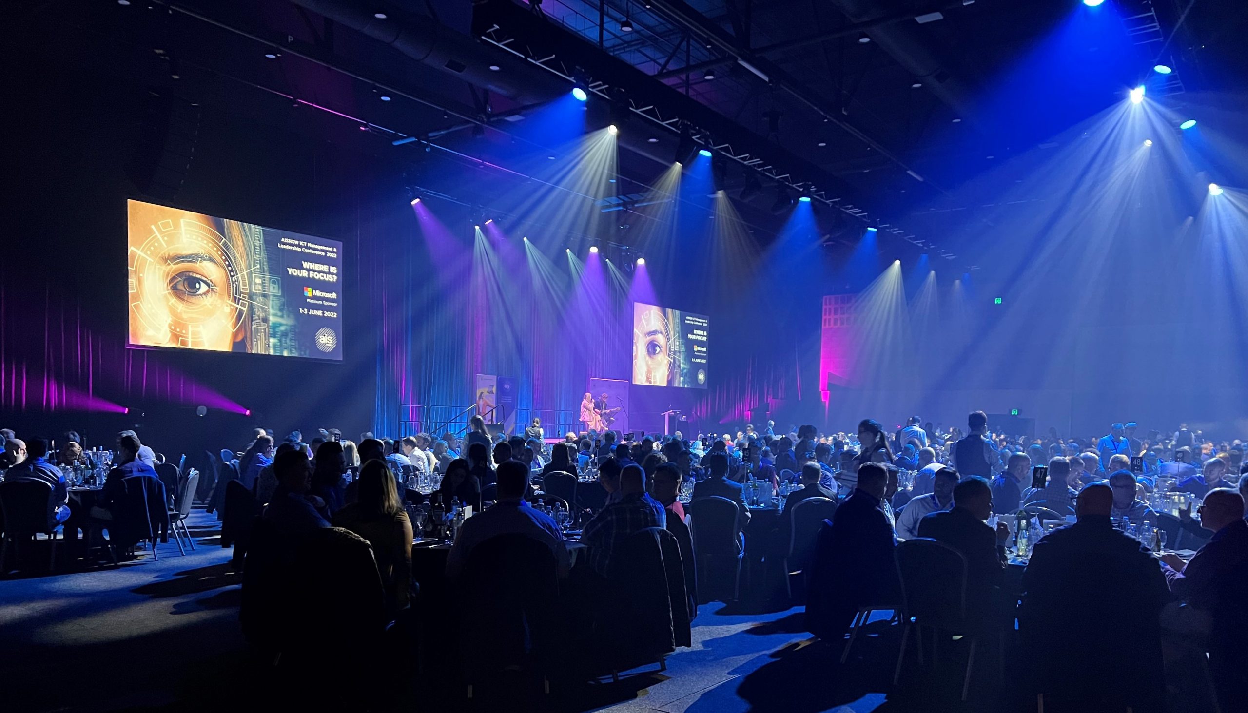 Guests dining at Leadership and Management conference on round tables with entertainment