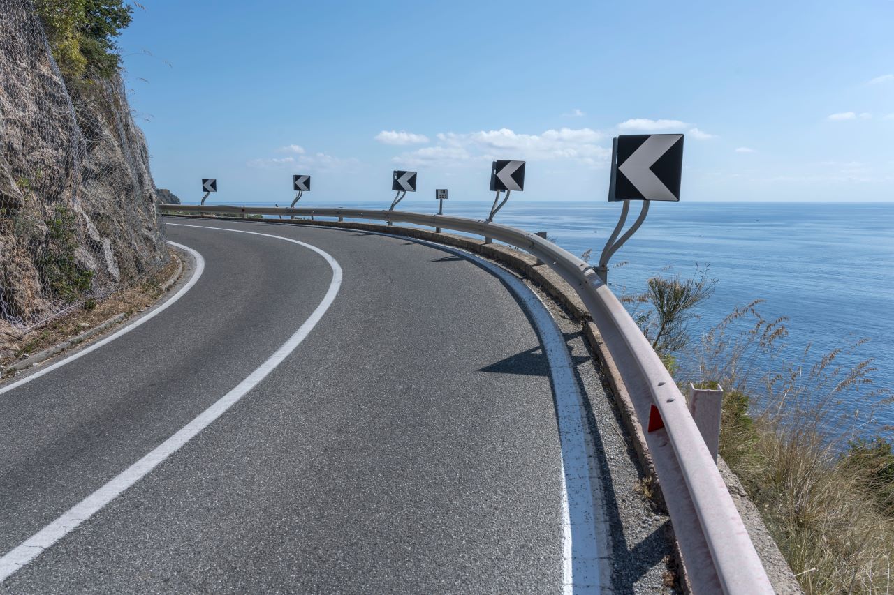 road wrapping around side of hill with an ocean view