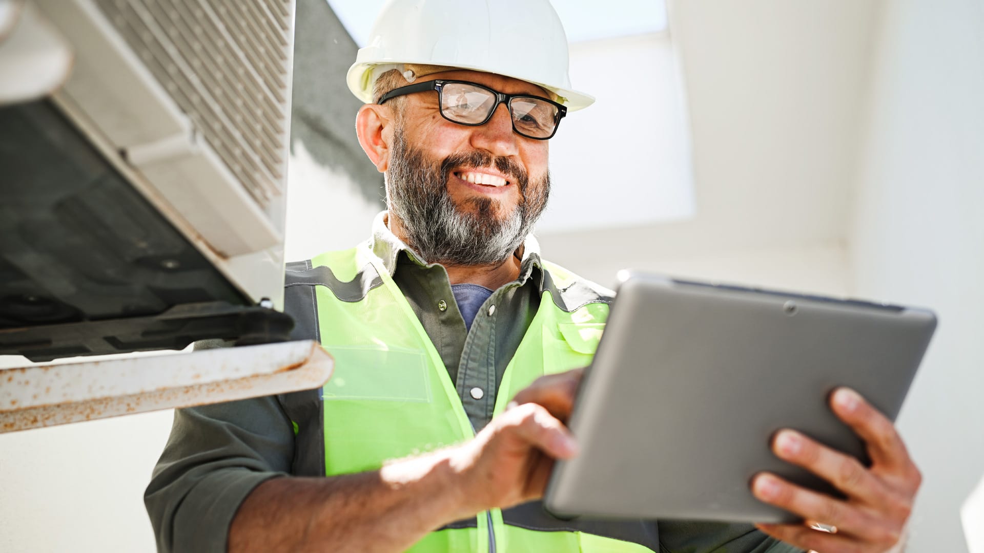 Man servicing an air-conditioner using an app on device
