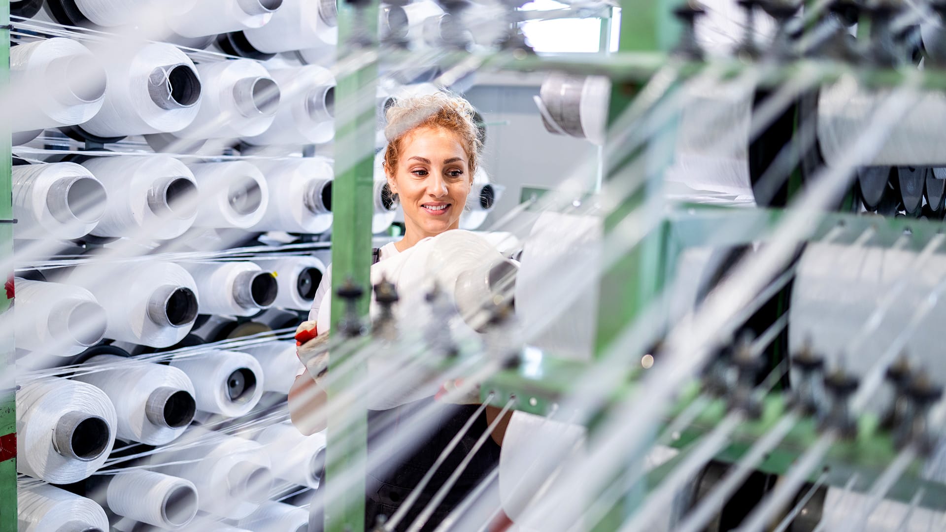 Woman inspecting cotton bundles