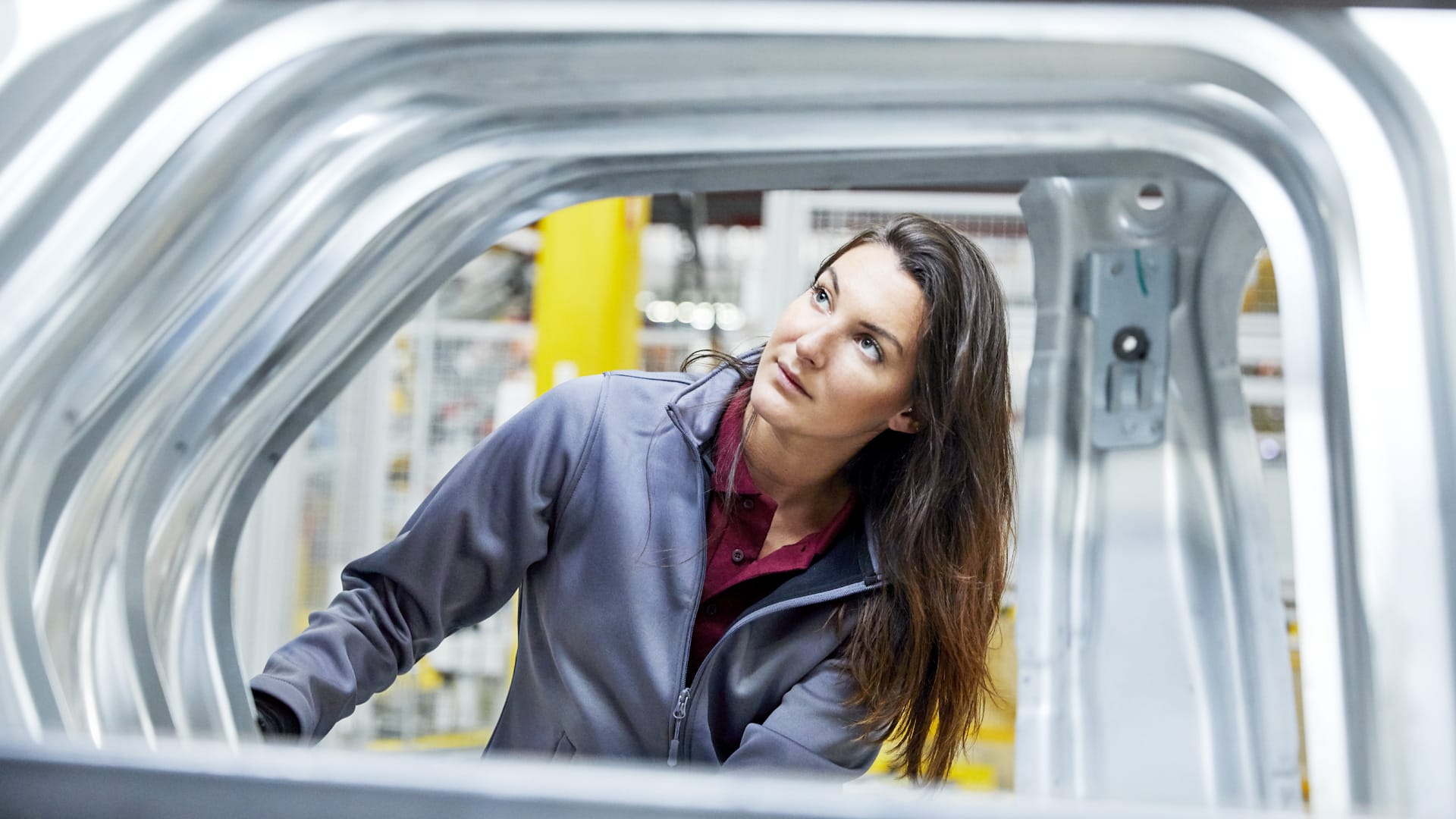 Woman inspecting car line for quality