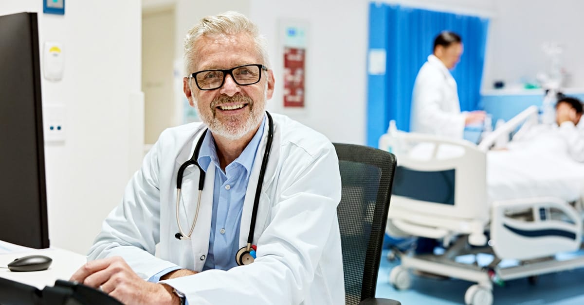 Doctor on computer smiling