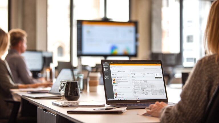 Staff on laptop using SmartSheet solution